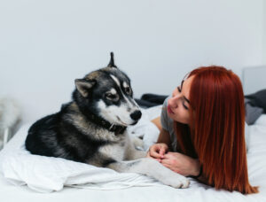women with pet dog on bed